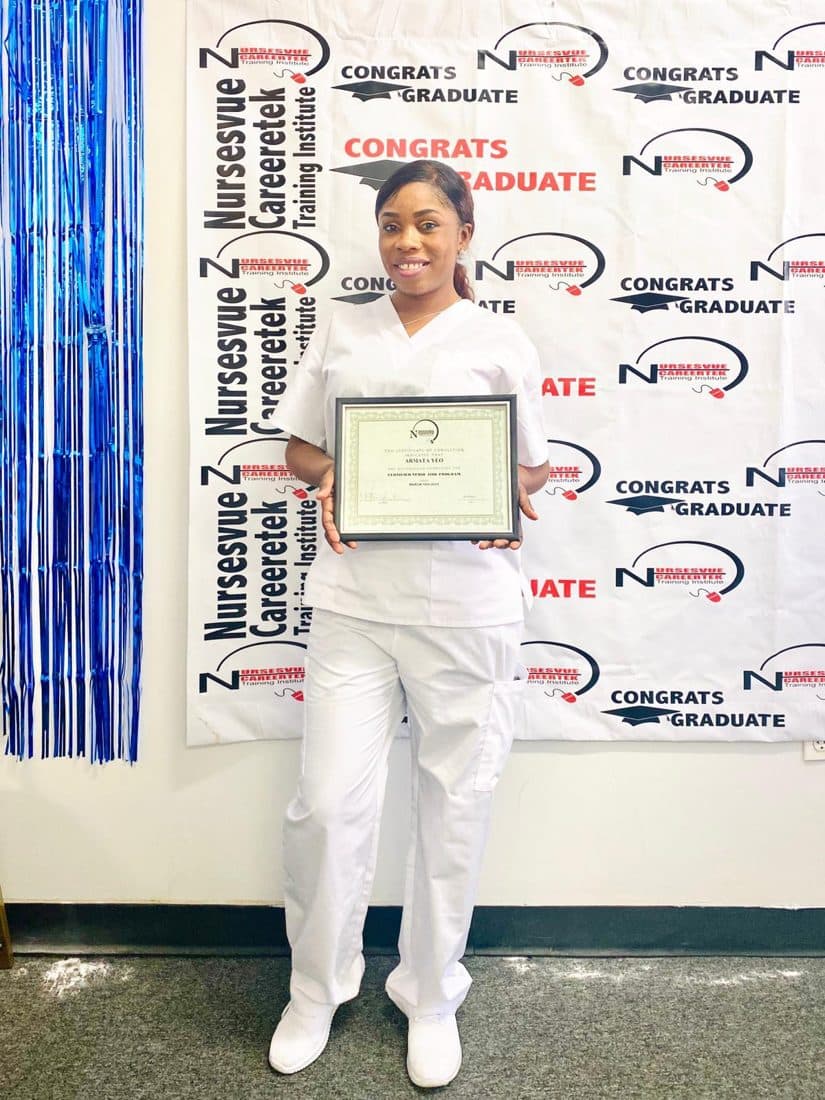 Graduate holding her healthcare certification at the nCareerTek banner
